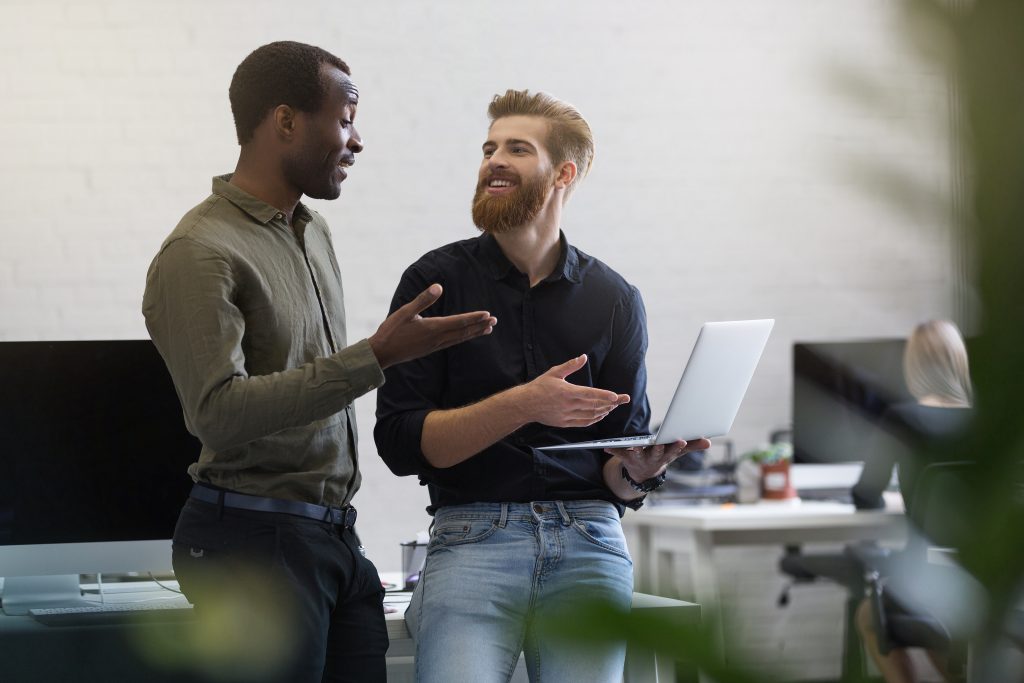 Cabinet de recrutement commercial à Toulouse : deux commerciaux échangeant autour d’un ordinateur portable