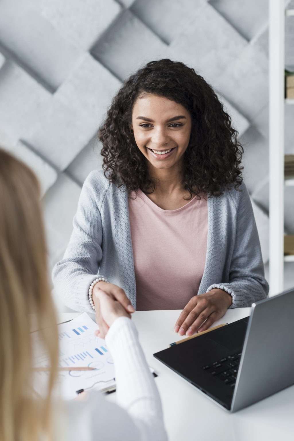 Recruteuse souriante accueillant un candidat en entretien de recrutement